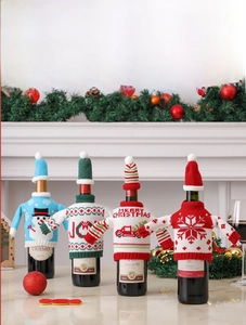 Set of four knitted Christmas wine bottle covers featuring snowman and holiday truck designs
