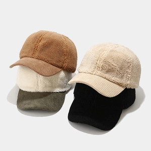 Detail of colorful fleece and corduroy baseball caps showing warm textured fabric