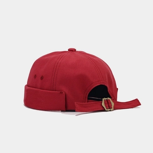 Detail view of the red miki hat showing adjustable metal buckle and canvas fabric texture
