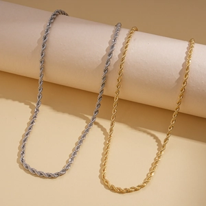 Detail view of gold and silver rope chain necklaces on minimalist display stands