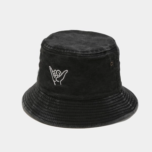 Macro detail of high-density washed cotton bucket hat with white gesture embroidery decoration