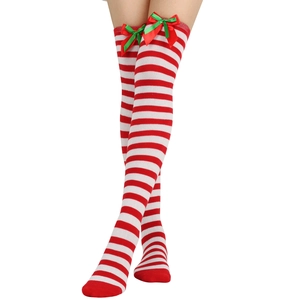 Detailed close-up of red and white striped over-knee socks with festive bow decorations