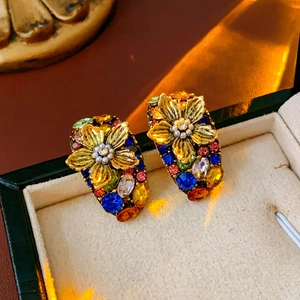 Macro shot of vintage gold flower earrings with multicolored gemstones and pearls