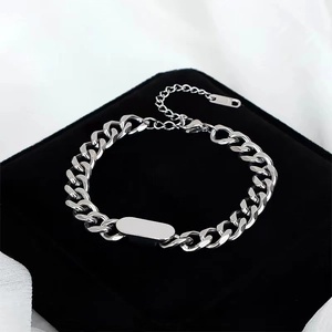 Dettaglio macro del bracciale a maglia cubana con targhetta in metallo lucido per incisioni