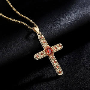 Religious 18K gold plated cross necklace with orange zircon gemstones on leather background