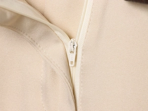 Détail du zip blanc et du tissu sergé beige sur le short de style urbain chic