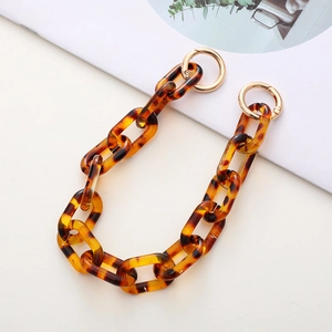 Detail of amber acrylic leopard print bag chain with gold metal ring fasteners
