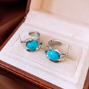 Gros plan de boucles d'oreilles vintage en argent avec turquoise bleu ciel en boîte