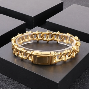 Detailed view of gold chunky chain bracelet with polished finish on black display stand