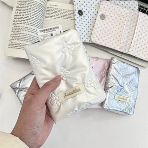 Close-up of quilted bow passport holder with silk sheen and Sezakka brand label