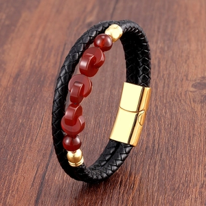 Detail of double-layer black braided leather bracelet with red agate beads and gold clasp