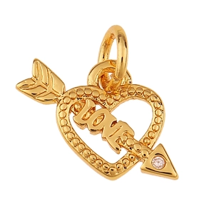 Primer plano de un colgante de corazón y flecha dorado con grabado LOVE y pequeño cristal