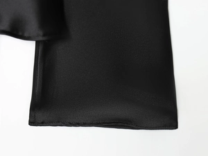 Macro detail of high-quality black satin shirt stitching and silky fabric texture