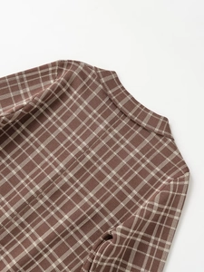 Close-up of the collar and shoulder stitching on a brown plaid knit cardigan
