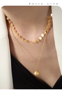 Close-up of layered 18K gold-plated necklace with flat disc chain and frosted bead pendant