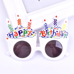 Close-up of white birthday cake party glasses with happy birthday text and candle icons
