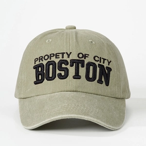 Close-up of Boston embroidery on vintage washed olive green baseball cap surface