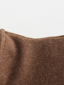 Detailed macro view of dark brown wool fabric texture on long sleeve jacket