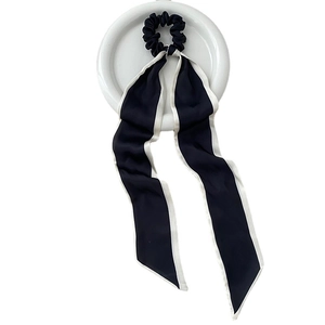 Elegante scrunchie in seta blu navy con bordo bianco e nastri lunghi su espositore