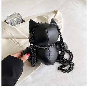 Detail of black animal-shaped plush bag featuring punk rivets and chunky chain strap