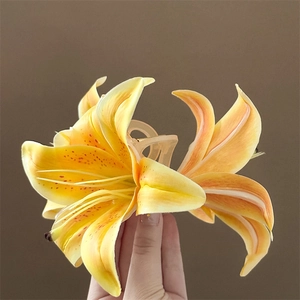 Detailed macro view of 3D orange lily flower hair claw clip with realistic petal texture