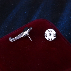 Classic silver airplane lapel pin badge on velvet background for formal suits