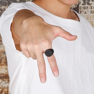 Detailed view of men's black stainless steel ring with textured geometric pattern engraving