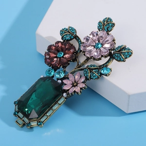 Macro shot of Baroque vase brooch featuring emerald crystals and rhinestones details