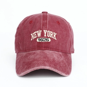 Gros plan sur casquette vintage en coton rouge avec broderie New York 1625 en fil blanc