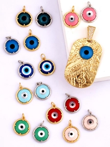 Flat lay of colorful enamel evil eye charms in round and rectangular gold frames