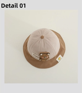 Close-up of baby corduroy bucket hat featuring 3D cartoon bear patch and Lucky embroidery