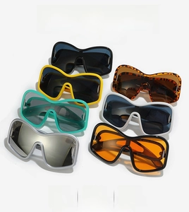 Detailed flat lay of oversized Y2K shield sunglasses in various vibrant fashion colors