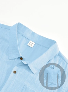 Detailed close-up of sky blue linen shirt collar and buttons with fabric texture