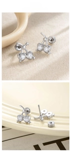 Macro shot of silver cherry heart stud earrings with zircon stones and screw-back closure