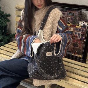 Winter heart pattern plush tote bag in grey lamb wool shown with model on bench