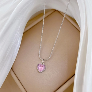 Close-up of pink heart pendant on silver steel chain in a premium beige jewelry box