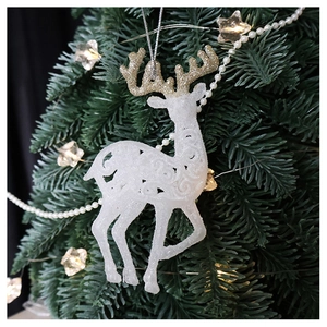 Close-up of a white glitter reindeer ornament with gold antlers hanging on a Christmas tree