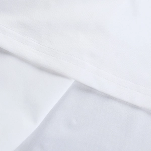 Détail de la double couture et texture du tissu sur la robe longue blanche fendue
