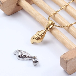 Detail of vintage conch shell pendants in gold and silver stainless steel finishes