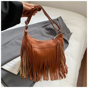 Detail shot of caramel brown fringe shoulder bag with textured pebble leather and tassel