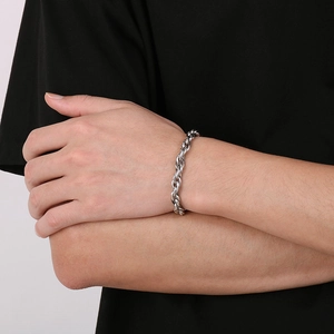 Close-up of a silver 7mm twisted chain bracelet worn on a male wrist with black shirt