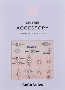 Detailed view of assorted silver nail charms with white rhinestones in packaging