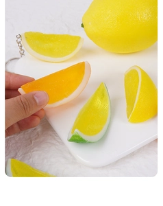 Detailed view of realistic PVC lemon and orange slices used as decorative keychains