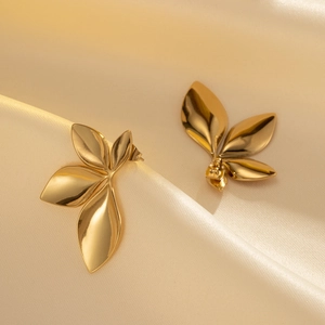 Polished gold petal earrings with leaf design on a champagne silk background