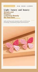 Detail of pink raffia woven butterfly earrings with gold metal frame and summer vibe