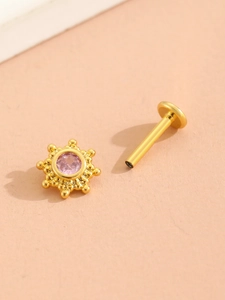 Detailed macro view of gold-plated pink gemstone sunburst stud with a flat back labret post