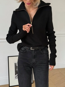 Detail of black slim fit knit sweater featuring a half-zip high collar and ribbed texture