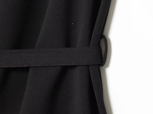 Close-up of fabric texture and waist belt with metal buckle on a black elegant vest