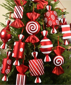 Detail of red and white candy ornaments with dots and stripes on a green Christmas tree