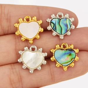 Detailed close-up of heart-shaped pendants with natural shell inlays and gold frames